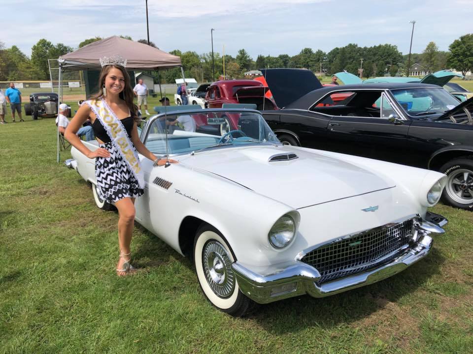 beauty queen posing standing next to vintage car